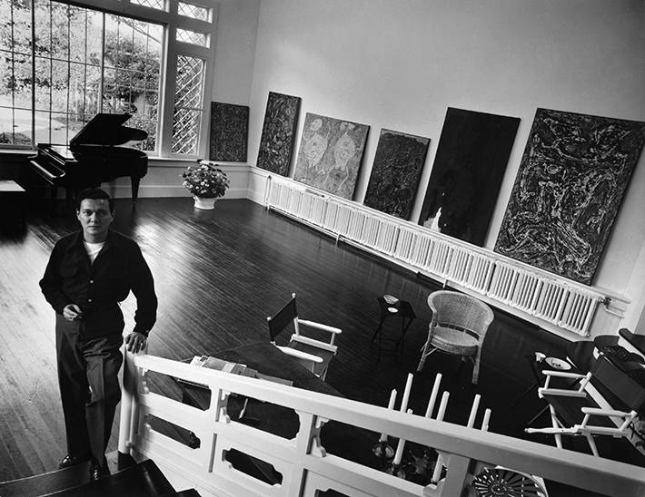 Alfonso Ossorio in the music room at The Creeks,  1952, with paintings by Dubuffet, Still and himself. Photograph by Hans Namuth.